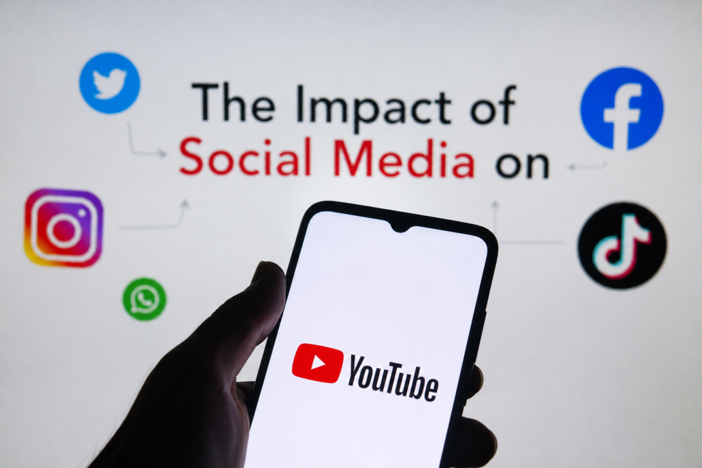Smartphone displaying the YouTube logo surrounded by popular social media platforms including Instagram, Facebook, TikTok, WhatsApp, and X, illustrating the impact of social media on YouTube channel growth and video promotion.